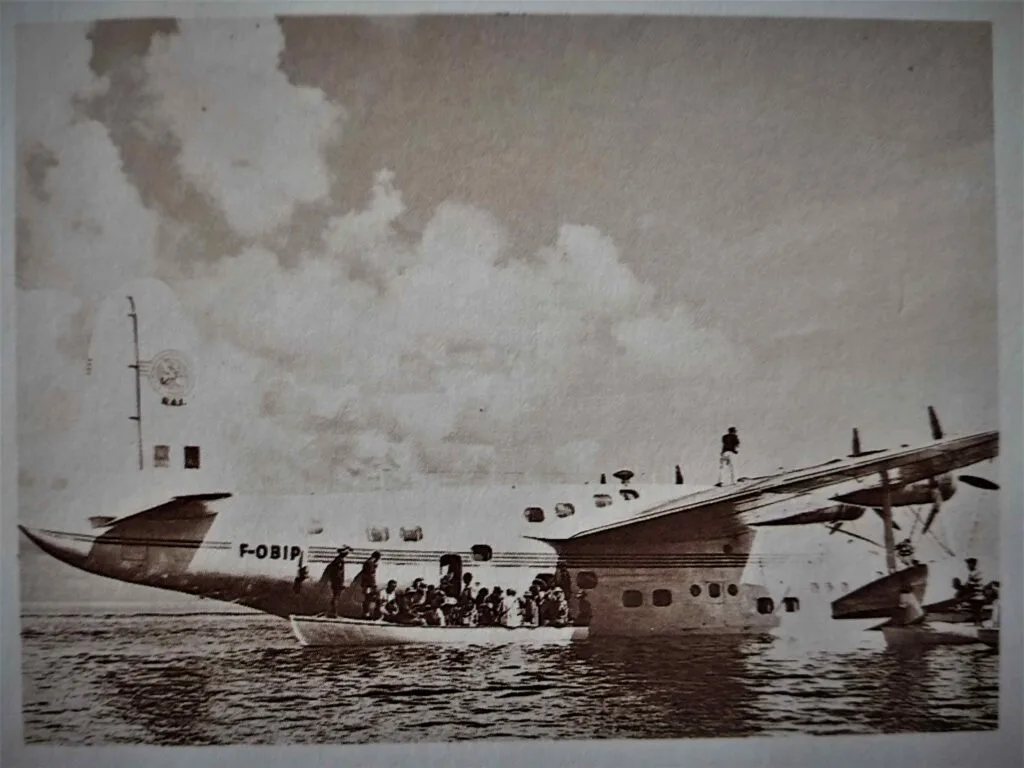 Black-and-white Photo of a Large Airplane Wrecked on the Shore, Its Fuselage Beached with a Crowd Gathered Nearby and Smoke in the Sky. Avion Bermuda 1960 Bd Avion Bermuda 1960 Bd Des Hydravions Dans Nos Lagons Laéronautique Racontée Par Albert Guilloux chevalier